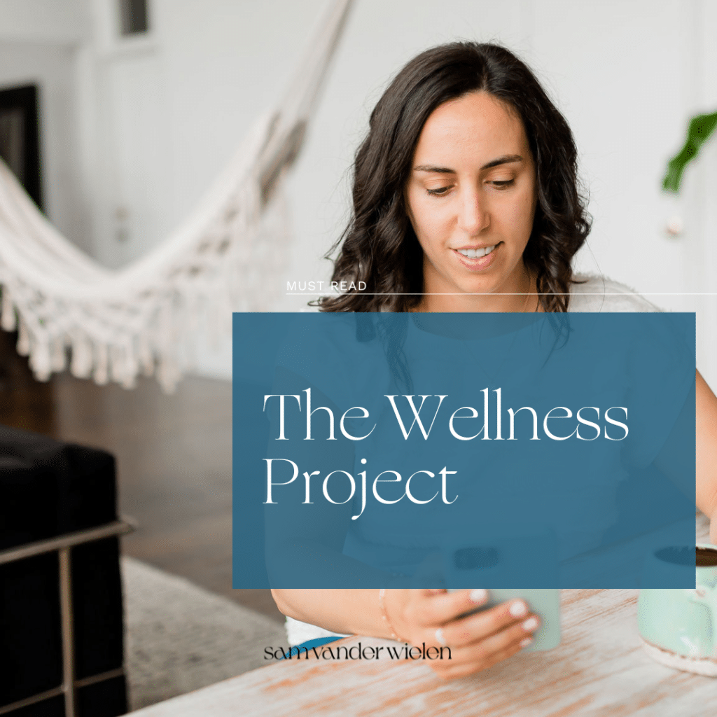 Woman sitting at desk with text overlay "The Wellness Project"