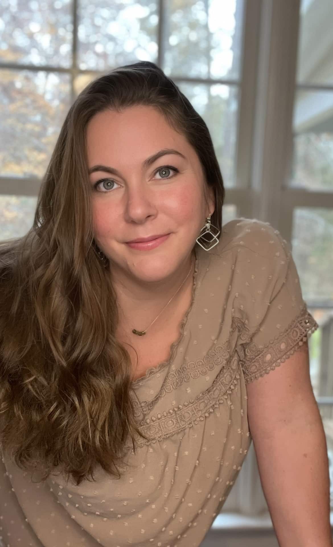woman with long brown hair and wearing dangling earrings
