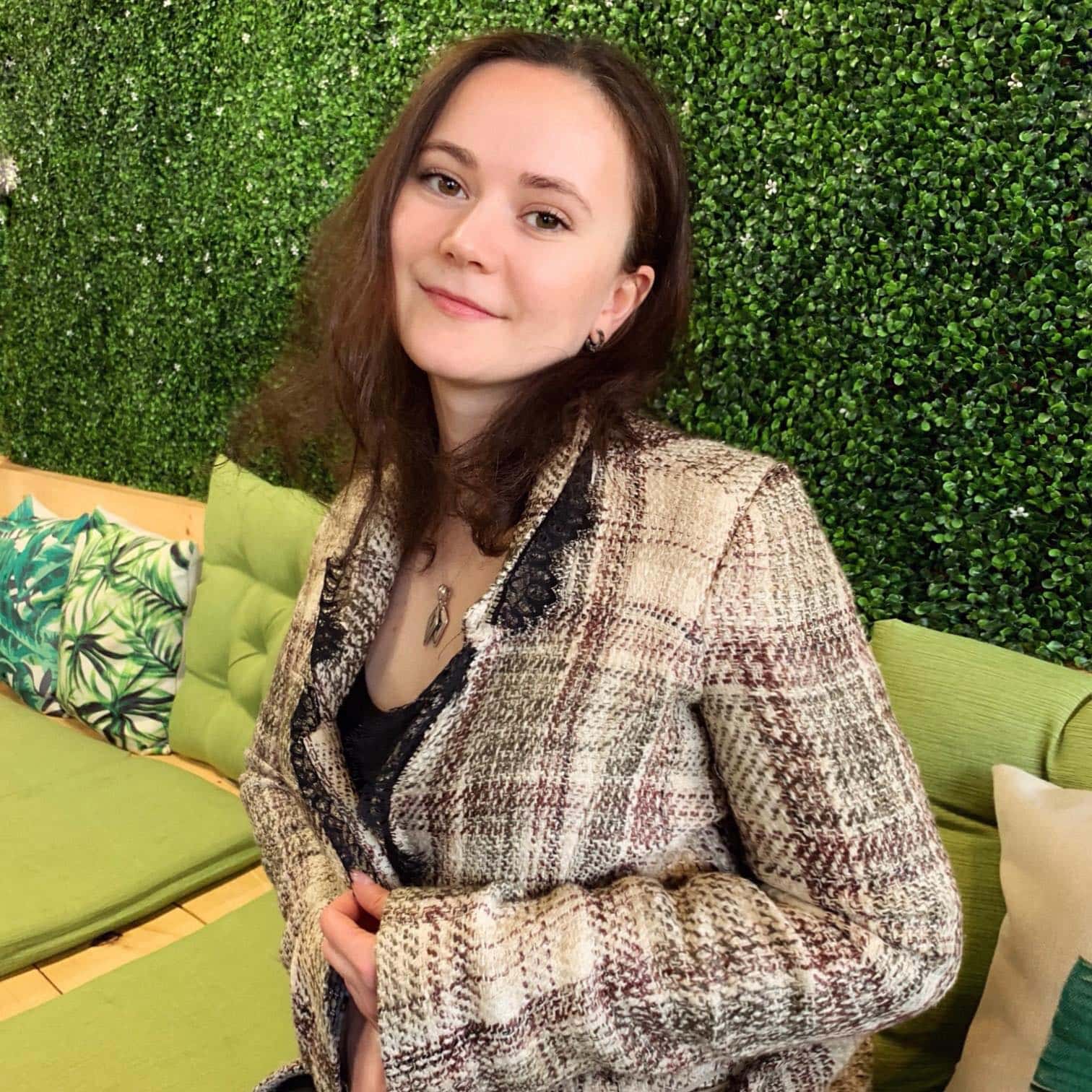 woman with shoulder length hair and wearing a tweed blazer