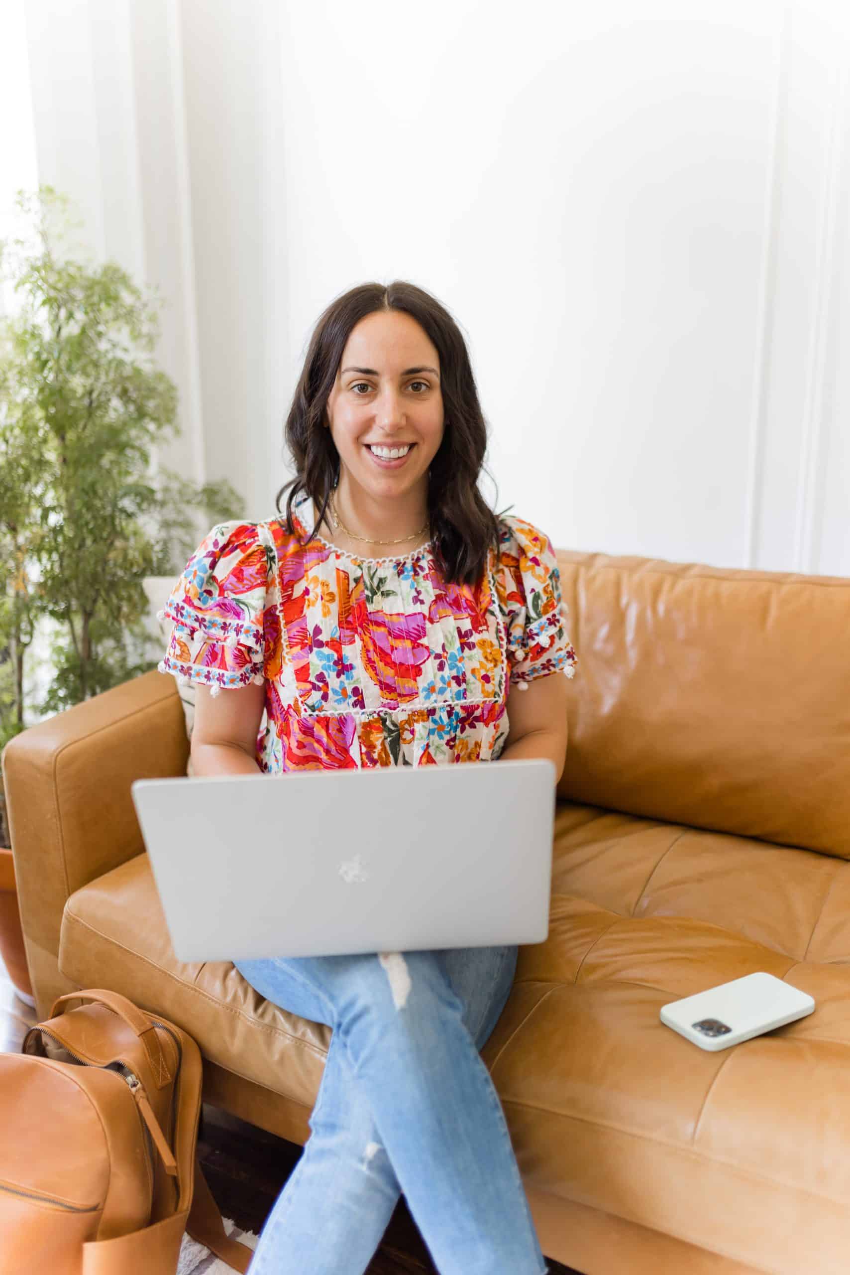 Woman with a floral top sitting with laptop